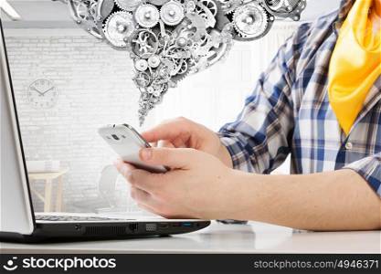 Hipster guy use laptop. Close view of guy in checked shirt using mobile phone and laptop
