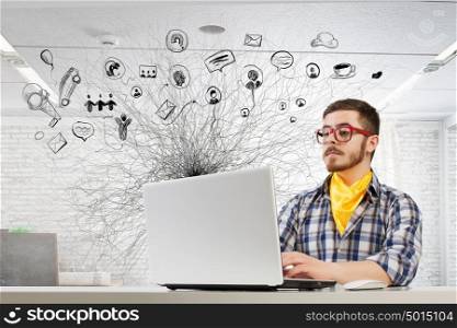 Hipster guy use laptop. Young handsome guy in red glasses surfing the Internet