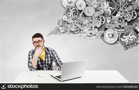 Hipster guy use laptop. Young pensive guy in red glasses surfing the Internet