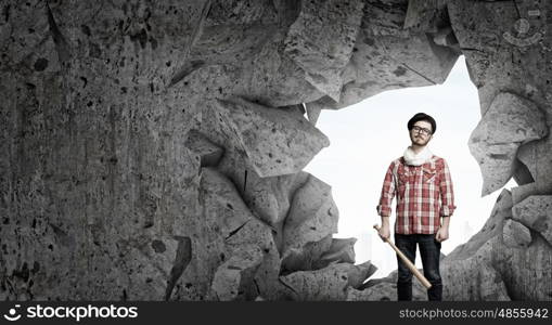 Hipster guy with bat. Furious hipster guy breaking wall with baseball bat