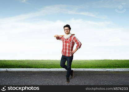 Hipster guy with bat. Young hipster guy with bat on asphalt road