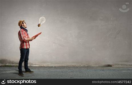 Hipster guy with book. Hipster guy with book in hands and glass bulbs in air