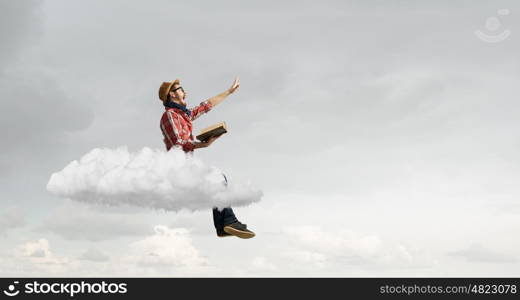 Hipster guy with book. Hipster guy with book in hands on cloud in sky