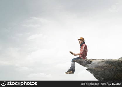 Hipster guy with book. Hipster guy with book in hands on rock top