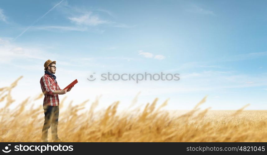 Hipster guy with book. Hipster guy with book in hands outdoors