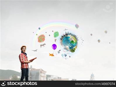 Hipster guy with book. Hipster guy with book in hands outdoors. Elements of this image are furnished by NASA