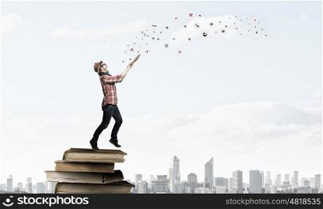 Hipster guy with book. Hipster student guy sitting on pile of books