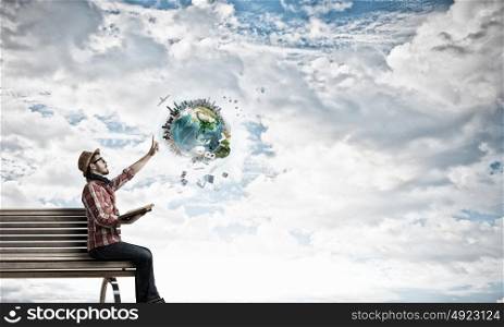 Hipster guy with book in hands. Hipster guy with book in hands sitting on wooden bench. Elements of this image are furnished by NASA