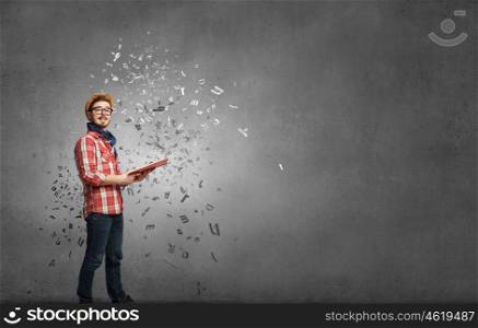 Hipster guy with book in hands. Hipster guy with book in hands in empty room