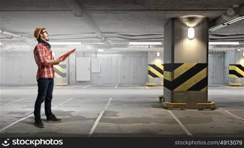 Hipster guy with book in hands. Hipster guy with book in hands in underground parking. Mixed media