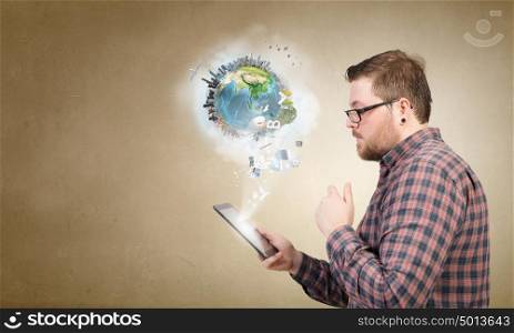 Hipster guy with tablet device. Young thoughtful man in checked shirt using tablet pc. Elements of this image are furnished by NASA