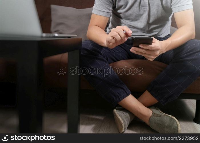hipster hand using digital tablet docking keyboard and smart phone for mobile payments online business,omni channel,sitting on sofa in living room