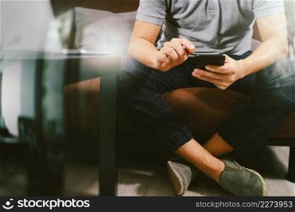 hipster hand using digital tablet docking keyboard and smart phone for mobile payments online business,omni channel,sitting on sofa in living room,filter effect