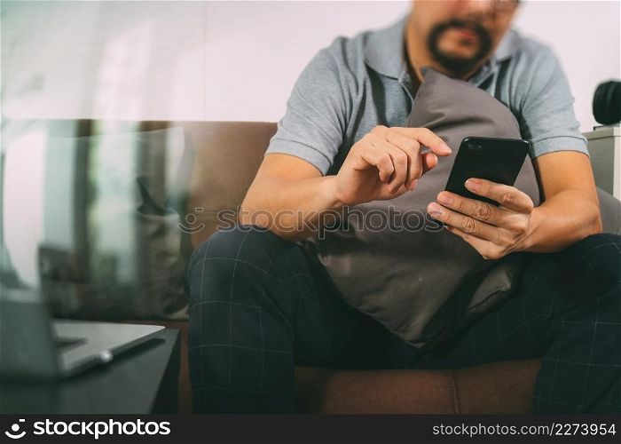 hipster hand using digital tablet docking keyboard and smart phone for mobile payments online business,omni channel,sitting on sofa in living room,filter effect