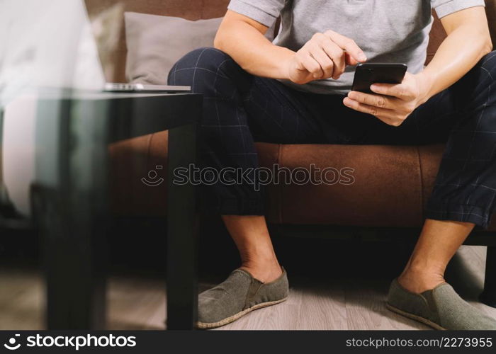 hipster hand using digital tablet docking keyboard and smart phone for mobile payments online business,omni channel,sitting on sofa in living room,filter effect