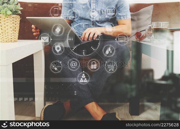 hipster hand using digital tablet docking keyboard,holding cradit card payments online business,sitting on sofa in living room,work at home concept,virtual interface graphic icons diagram