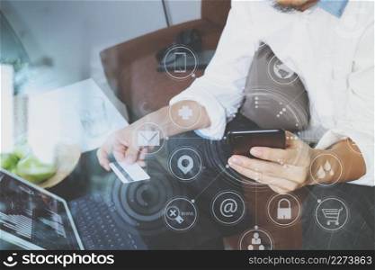 hipster hand using smart phone and laptop compter,holding cradit card payments online business,sitting on sofa in living room,green apples in wooden tray,virtual interface screen