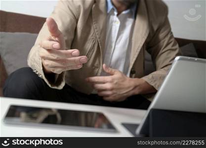 hipster hand using smart phone,digital tablet docking keyboard,coffee cup, payments online business,sitting on sofa in living room,work at home concept