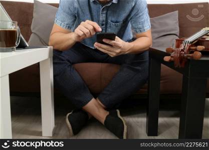 hipster hand using smart phone,digital tablet docking keyboard,holding cradit card payments online business,sitting on sofa in living room,work at home concept