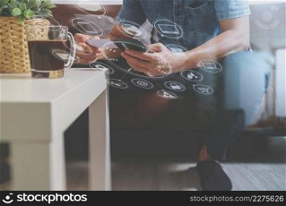 hipster hand using smart phone,digital tablet docking keyboard,holding cradit card payments online business,sitting on sofa in living room,work at home concept,virtual interface graphic icons diagram