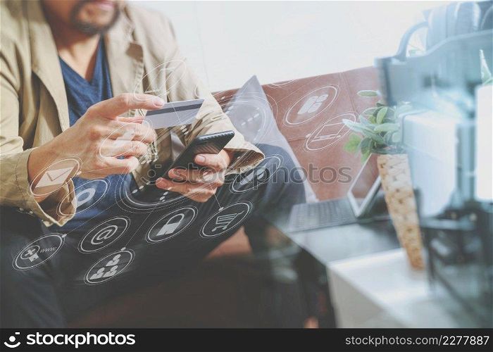 hipster hand using smart phone,digital tablet docking keyboard,holding cradit card payments online business,sitting on sofa in living room,work at home concept,virtual interface graphic icons diagram