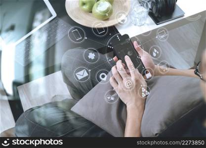hipster hand using smart phone for mobile payments online business,headphone,sitting on sofa in living room,green apples in wooden tray,graphic interfce icons virtual screen