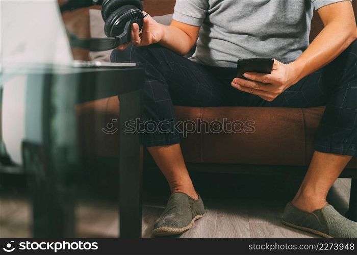 hipster hand using smart phone for mobile payments online business,headphone,sitting on sofa in living room,filter effect