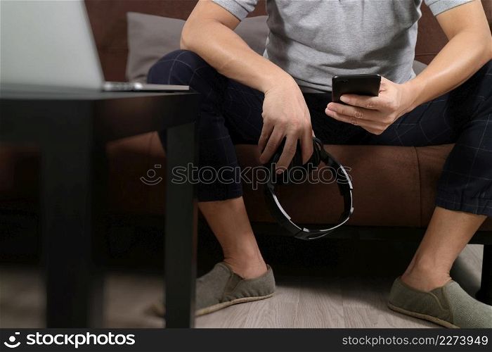 hipster hand using smart phone for mobile payments online business,headphone,sitting on sofa in living room