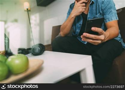 hipster hand using smart phone for mobile payments online business,sitting on sofa in living room,green apples in wooden tray,filter