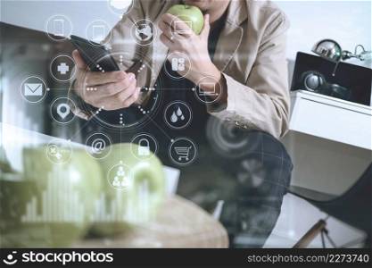 hipster hand using smart phone for mobile payments online business,sitting on sofa in living room,holding green apple in wooden tray,virtual computer interface omni channel
