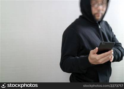 hipster male in a hood hand using mobile phone payments online shopping,omni channel,front view