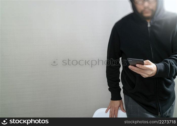hipster male in a hood hand using mobile phone payments online shopping,omni channel,front view