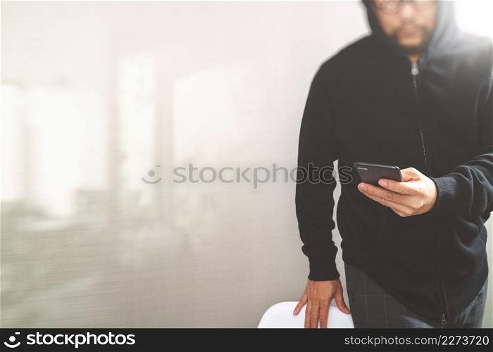 hipster male in a hood hand using mobile phone payments online shopping,omni channel,front view,filter effect
