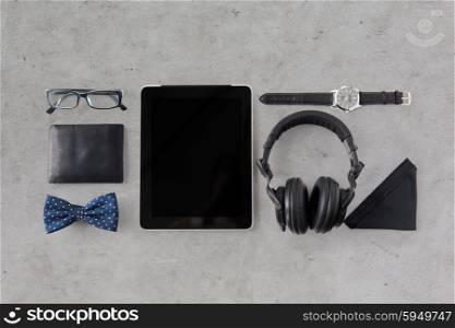 hipster personal stuff and objects concept - tablet pc computer, headphones, wallet, eyeglasses and wristwatch over gray concrete background