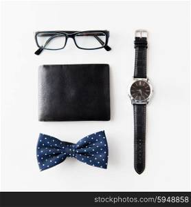 hipster personal stuff and objects concept - wallet, eyeglasses, bowtie and wristwatch on table