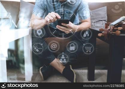 hipster using smart phone and digital tablet computer and sitting on sofa in living room,work at home concept,virtual interface graphic icons diagram
