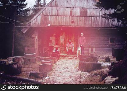 hipsters couple portrait, two young man with white husky dog sitting in front of old wooden retro house. frineds together in front of old wooden house