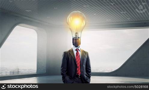 His head full of great ideas. Businessman in modern interior with light bulb instead of head