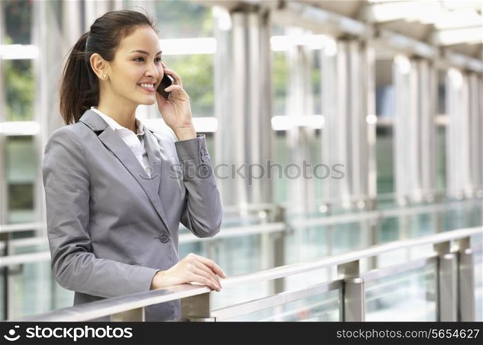 Hispanic Businesswoman Outside Office On Mobile Phone