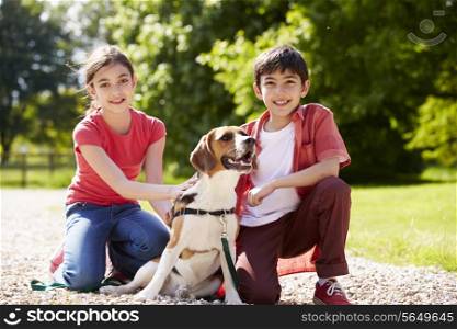 Hispanic Children Taking Dog For Walk In Countryside