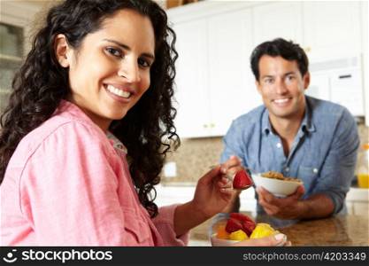 Hispanic couple eating cereal and fruit
