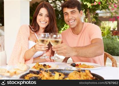 Hispanic Couple Enjoying Outdoor Meal At Home Together