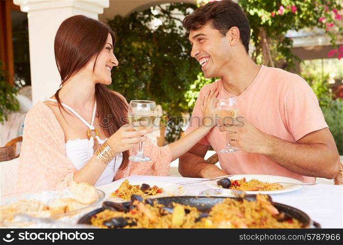Hispanic Couple Enjoying Outdoor Meal At Home Together
