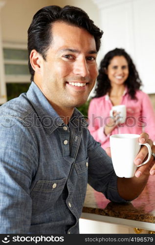 Hispanic couple relaxing in kitchen