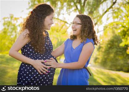 Hispanic Daughter Feels Baby Kick in Pregnant Mother&rsquo;s Tummy Outdoors At the Park.