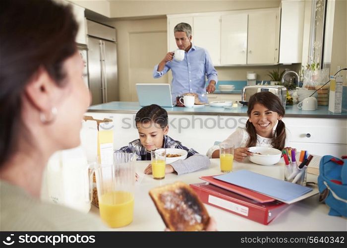Hispanic Family Eating Breakfast At Home Before School