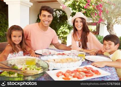 Hispanic Family Enjoying Outdoor Meal At Home Together