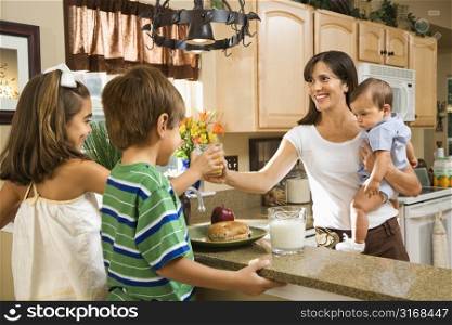 Hispanic family in kitchen with breakfast.