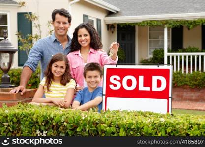 Hispanic family outside home with sold sign
