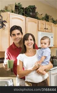 Hispanic family portrait in home kitchen with baby.